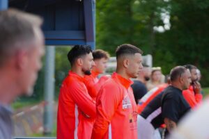 Einwechselspieler des Türkischen SV Lübeck bereiten sich auf ihren Einsatz vor.